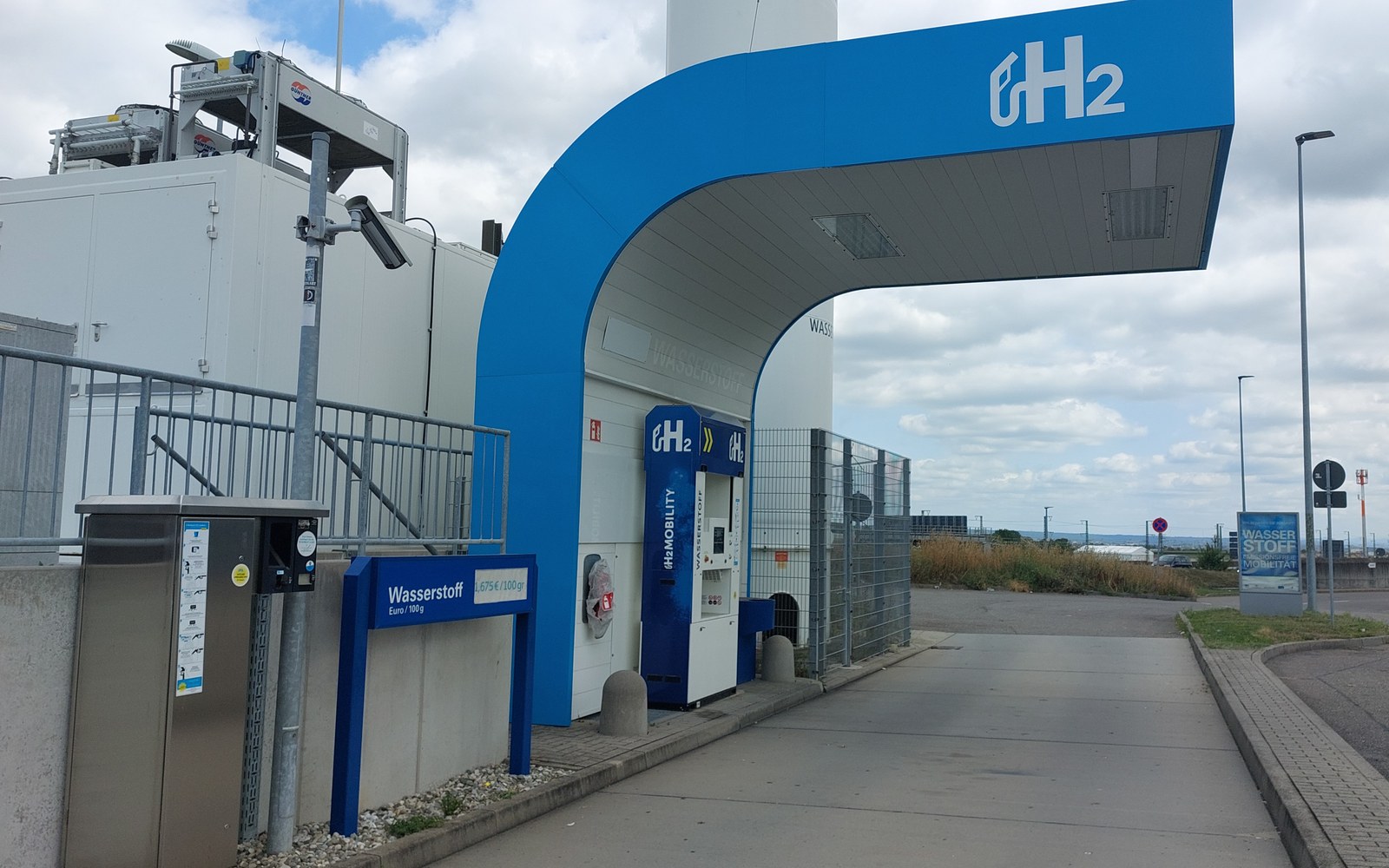 A hydrogen refueling station with a large H2 logo on the canopy